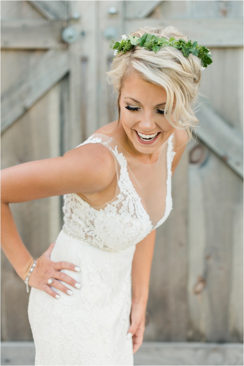 Bride in lace dress with green flower crown in front of barn door. Click here to see more from this wedding: http://jennakutcherblog.com/kirsten-billy-creekside-farm-wedding/